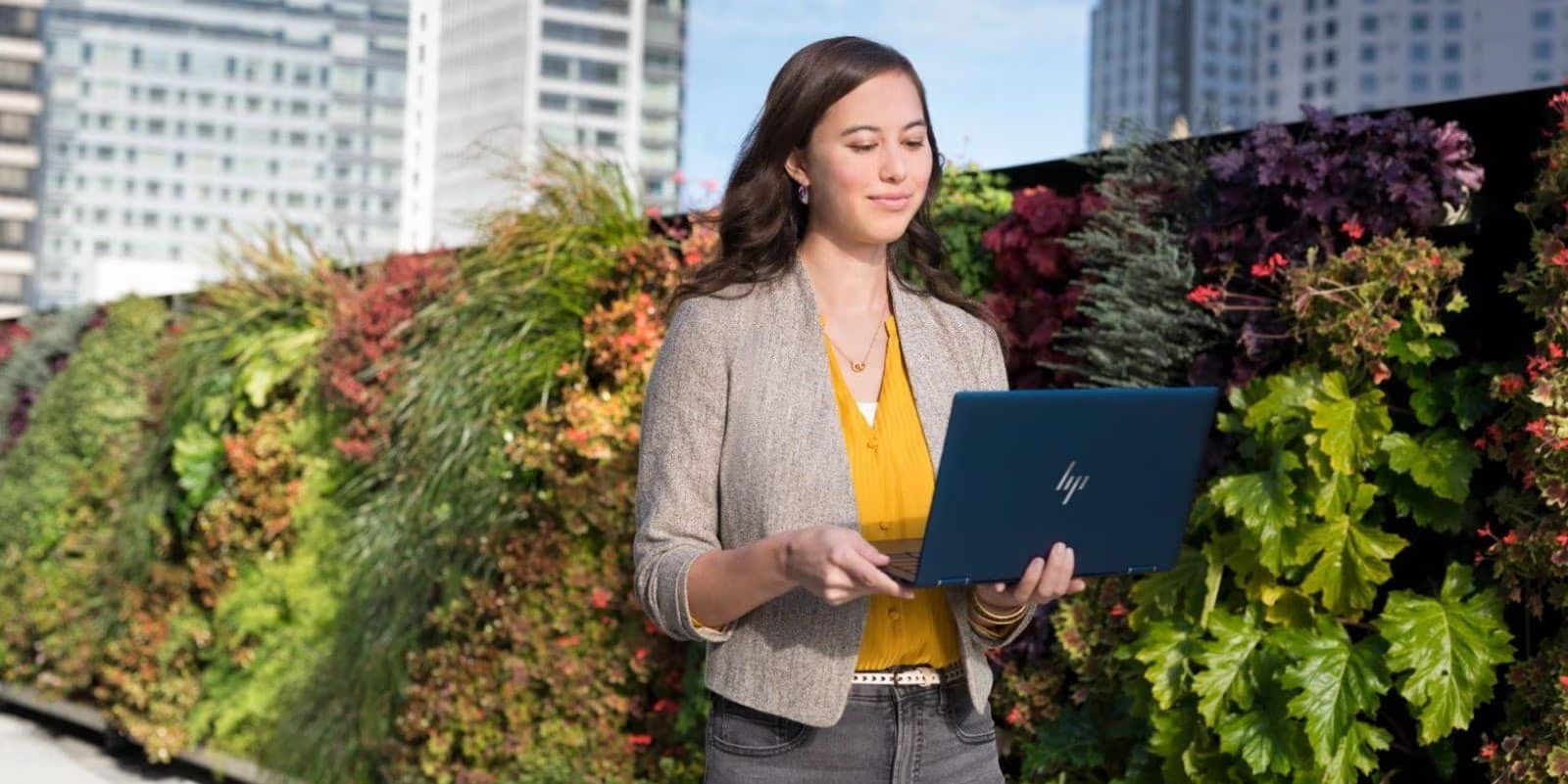 Profesional con portátil en jardín urbano. Trabajo remoto en espacio verde