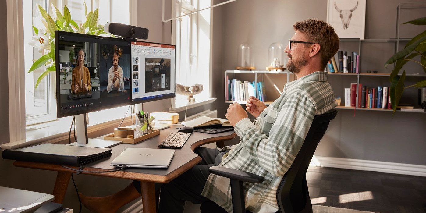 Hombre profesional en videollamada con monitor HP y cámara HP Poly en oficina en casa- trabajo remoto empresarial